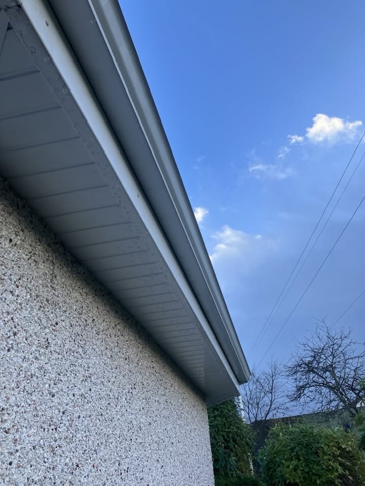 Clean guttering and fascia on a rendered house after gutter cleaning